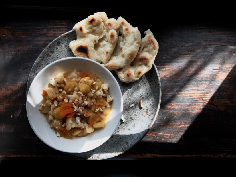 bowl of vegan curry and naan bread